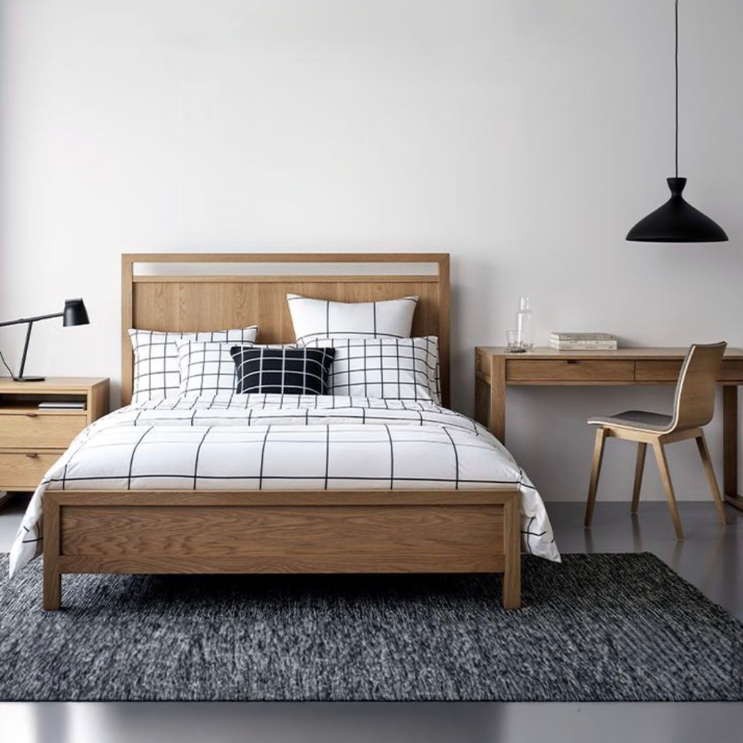 Bedroom with FULTON wood panel bed, desk, and chair on a gray rug.
