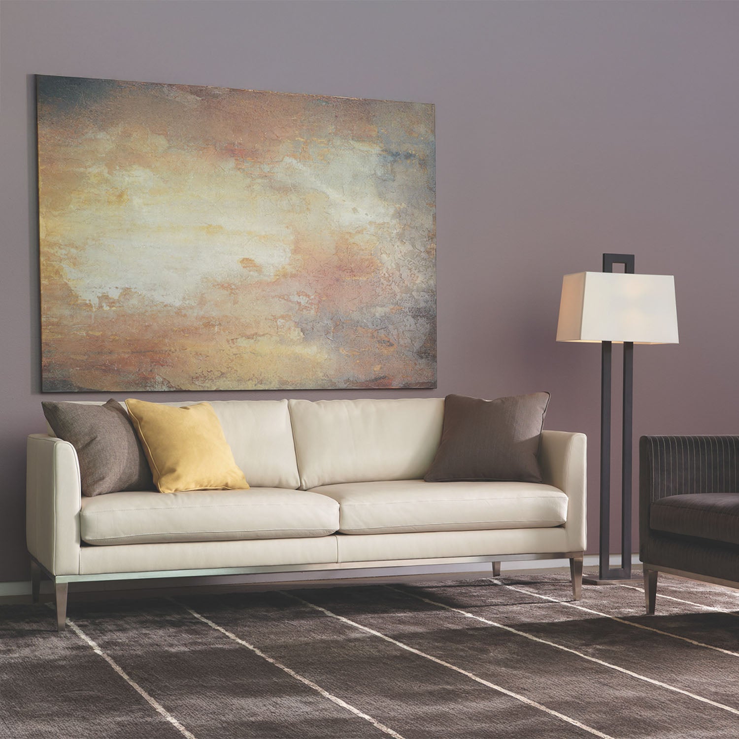 Modern living room with a beige HENLEY sofa, abstract painting, and floor lamp.