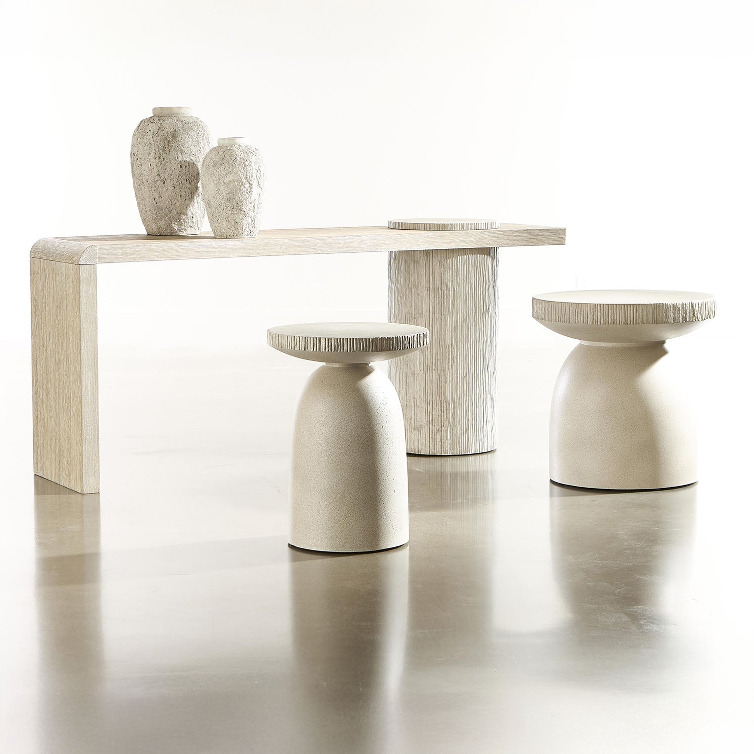 Set of modern Antibes furniture from Bernhardt including a table and stools on a reflective surface with a white background