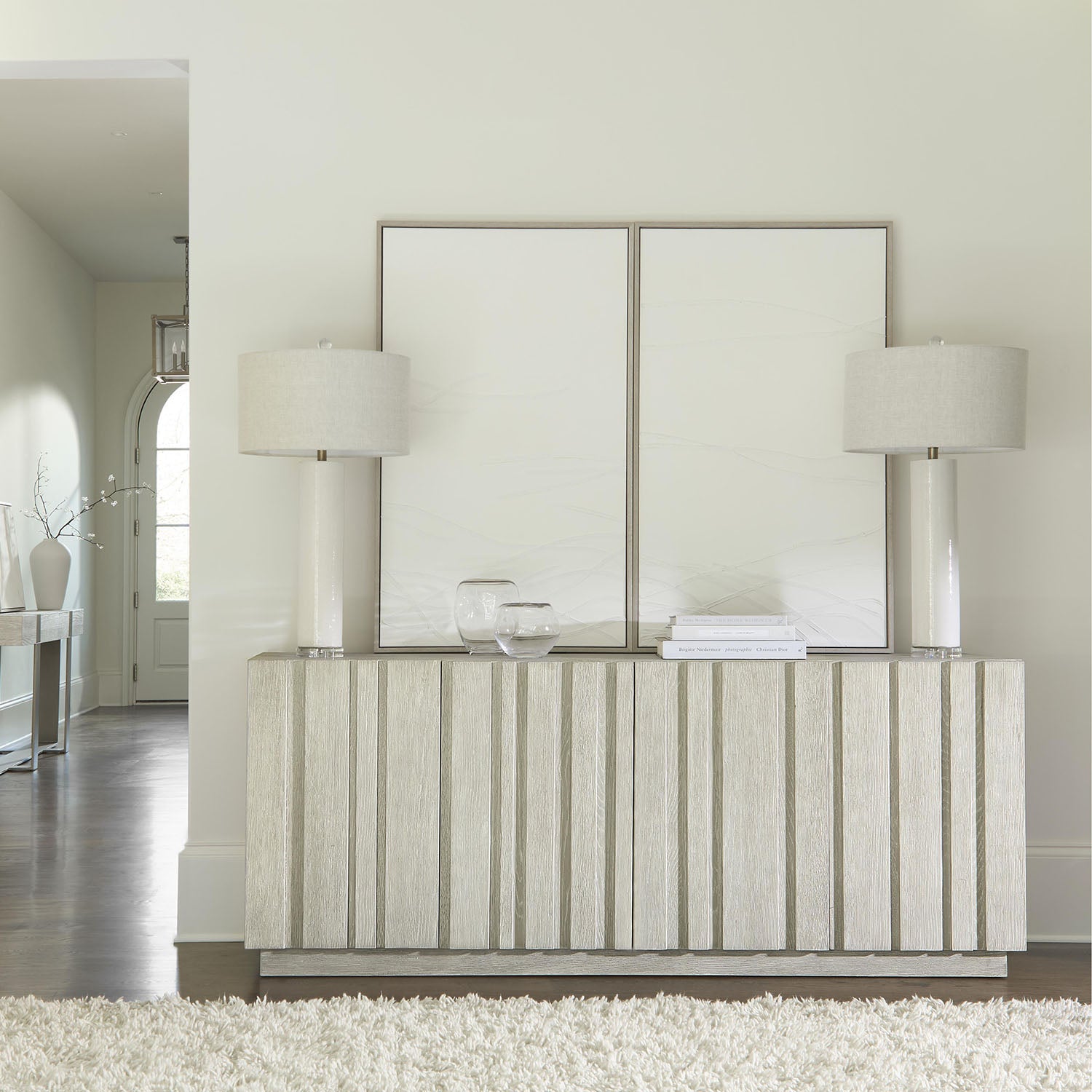 Modern interior design with a Tempo Credenza from Bernhardt, table, lamps, and decorative items.
