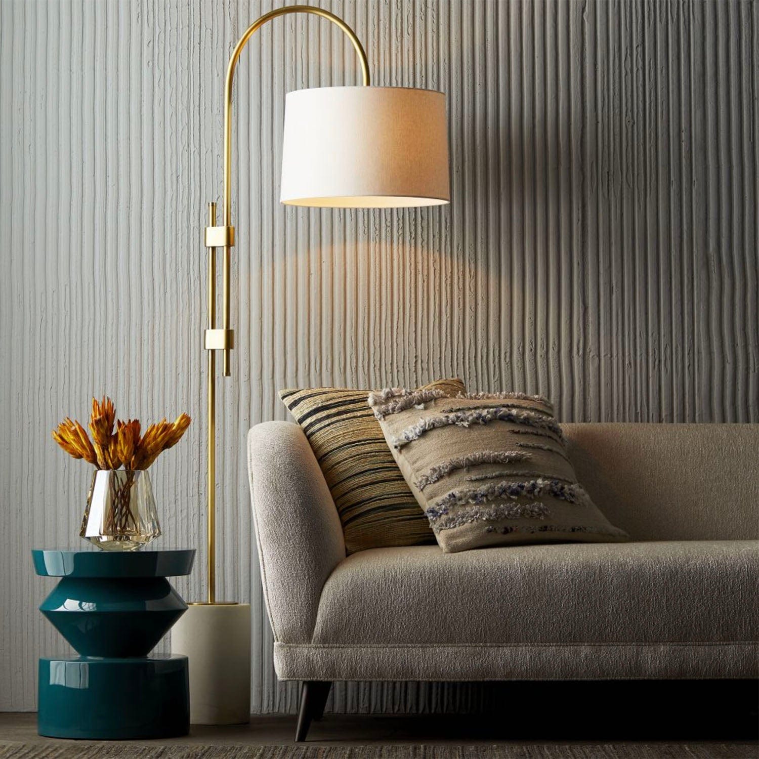 Living room with a gray sofa, floor lamp, and decorative items.