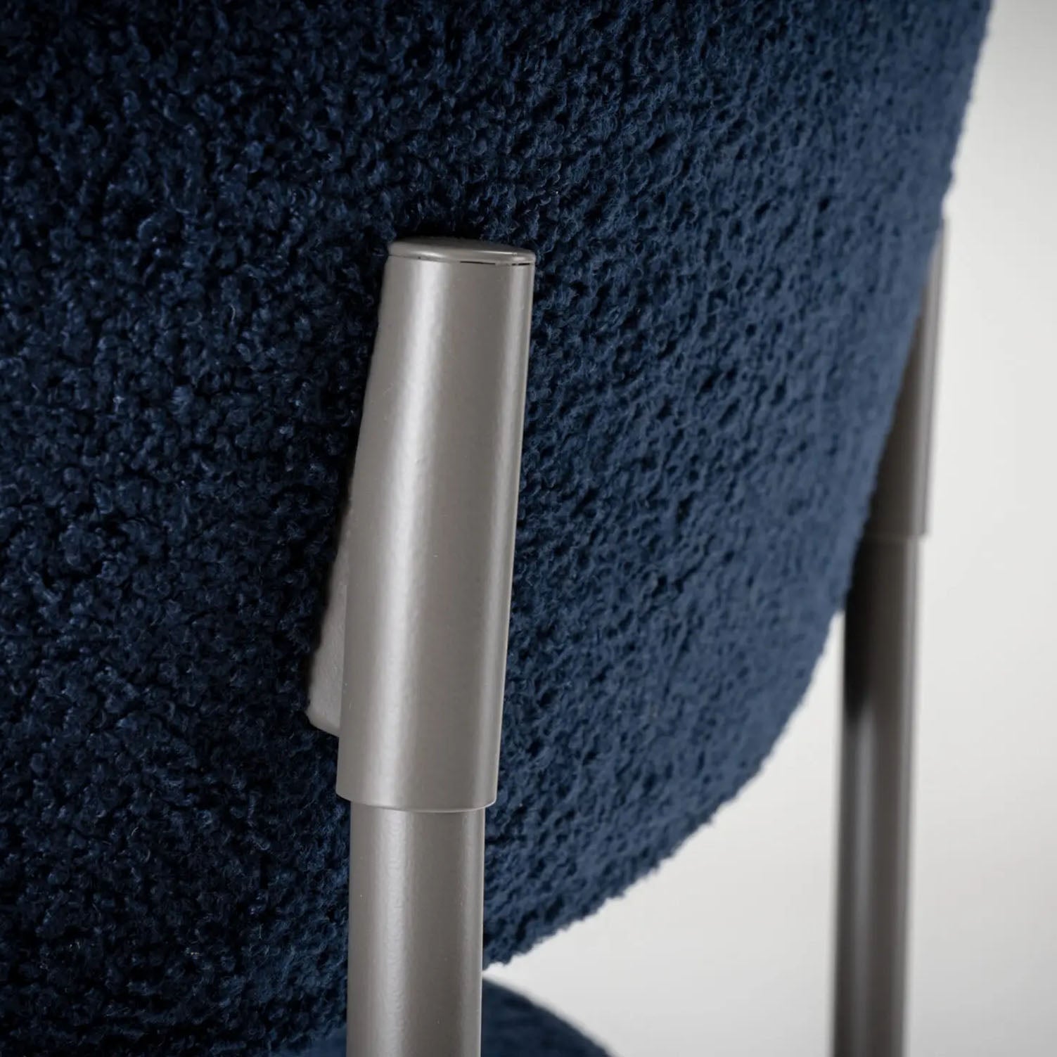 Close-up of a metallic handle on a blue textured chair