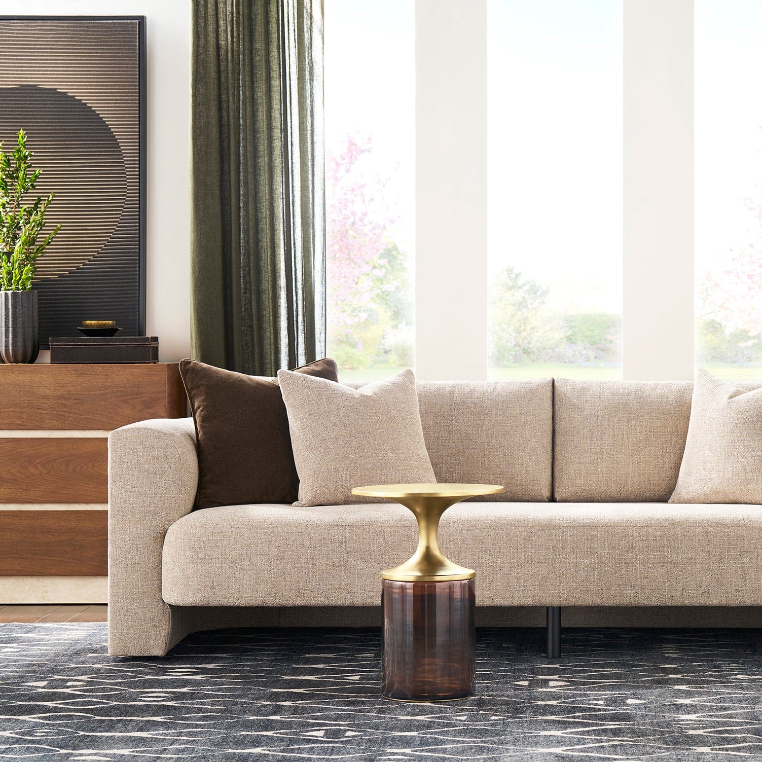 Modern living room with a beige sofa, decorative pillows, and an Aiden Spot table.