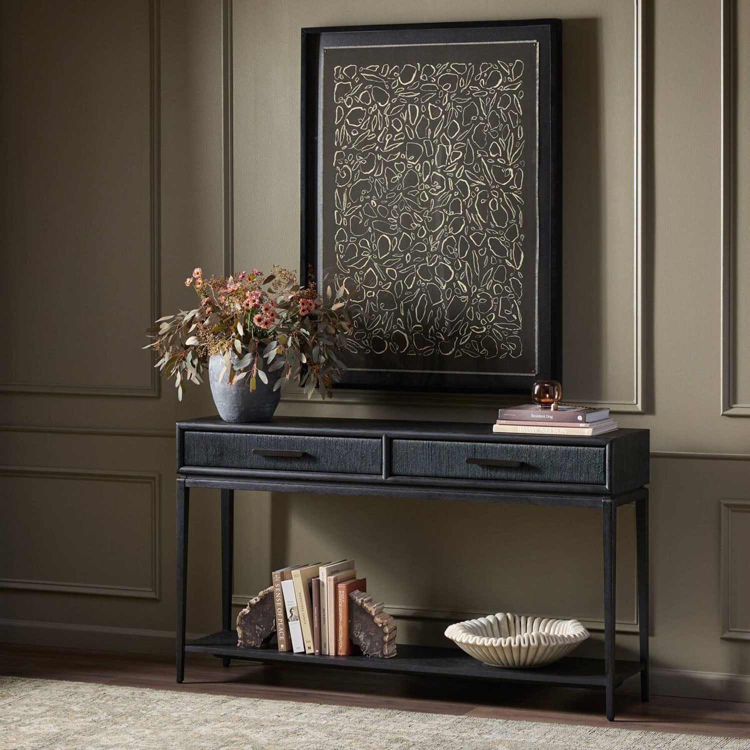 Rosenell Black Oak Console table with decorative items against a wall with framed artwork
