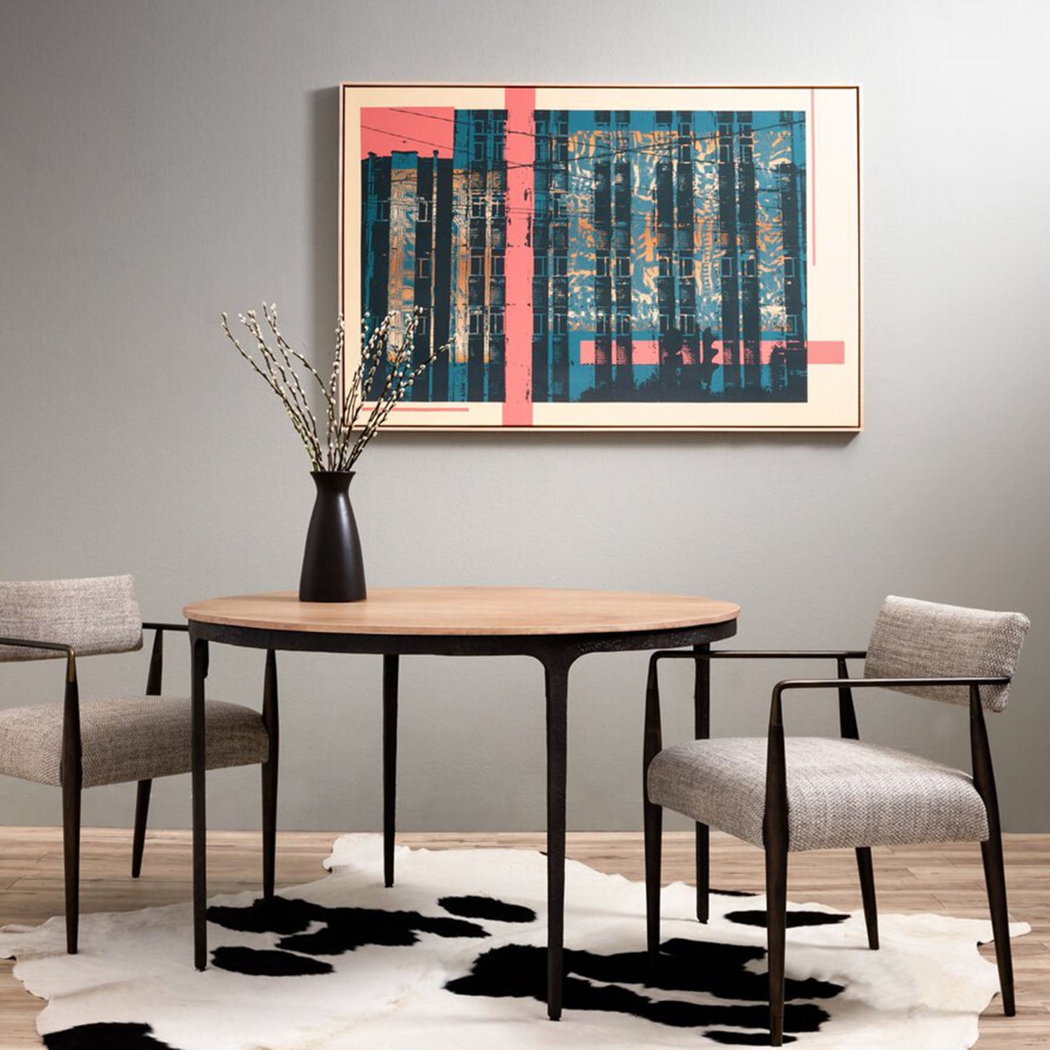 Dining room with round wooden table and Waldon chairs, abstract painting on the wall.