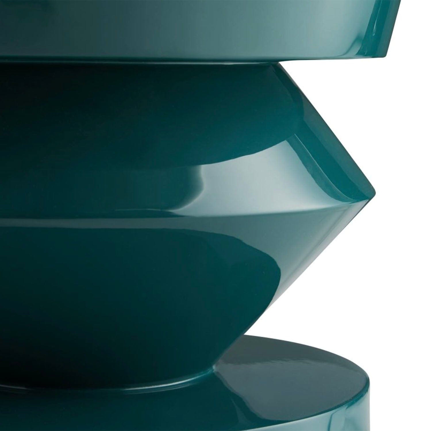 Teal-colored spiral end table close up on a white background
