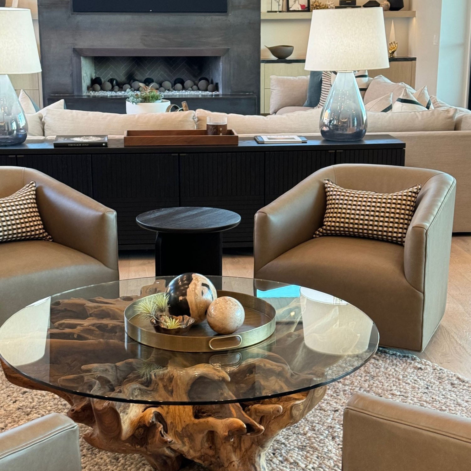 Modern living room with Haney Swivel chairs, glass coffee table, and decorative items.
